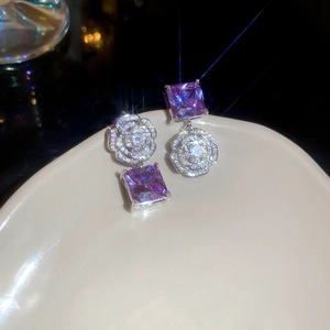 Macro shot of a purple crystal tassel earring with a sparkling flower stud and star light effect