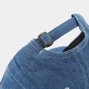 Macro detail of dark blue denim baseball cap with vintage brass adjustable metal buckle