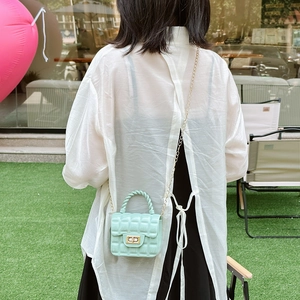 Mint green quilted jelly handbag with metal chain strap shown on a model's shoulder