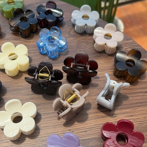 Variété de pinces à cheveux fleurs de 5cm en couleurs vives sur surface en bois