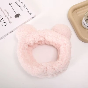 Detailed close-up of a pink plush headband with cute bear ears for skincare routine