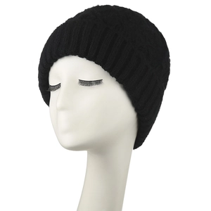 Detail of black cable knit beanie featuring thick texture and ribbed cuff design