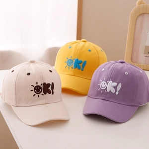 Close-up of three colorful kids baseball caps with sun and OK embroidery detail