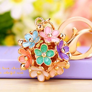 Macro detail of multi-colored floral keychain with enamel finish and gold metal hook