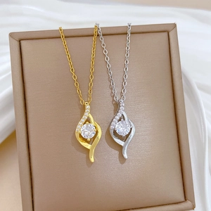Minimalist gold and silver titanium necklaces with streamlined crystal pendants in a box