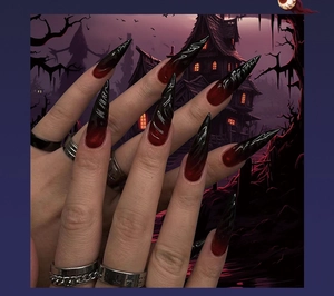 Detail of long stiletto press on nails with red and black 3D swirl gradient design