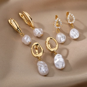 Elegant gold geometric earrings with freshwater baroque pearls on silk background
