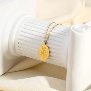 Détail du collier avec pendentif rose en or 18 carats sur fond en soie crémeuse