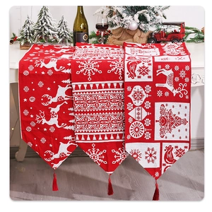 Detailed view of red and white knitted Christmas table runners with reindeer patterns