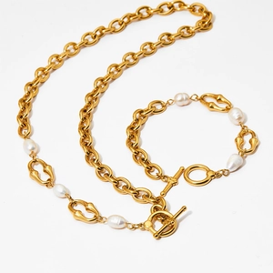 Detail of golden metal chain necklace and bracelet set with baroque pearls