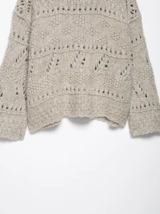 Detailed close-up of oatmeal hollow knit cardigan showing thick yarn and ribbed hem