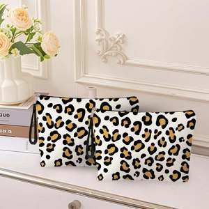 Two-piece leopard print makeup bag set on a vintage vanity with floral background