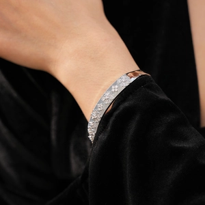 Detailed view of silver flower bangle with cubic zirconia on a wrist model