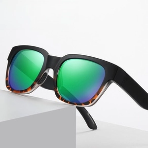 Detail of polarized sunglasses showing colorful green mirror coating and tortoise shell frame