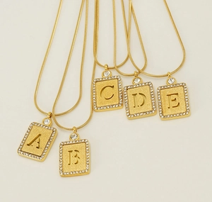 Détail de pendentifs lettres A à E plaqués or 18 carats avec incrustations de cristaux