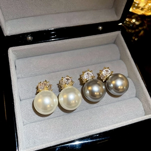 Détail de boucles d'oreilles en perles et zircons carrés en blanc et gris chic