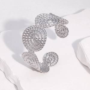 Macro shot of silver cuff bracelet featuring intricate twisted spiral metal textures