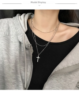 Detailed view of triple-layered silver titanium steel necklace with a cross pendant