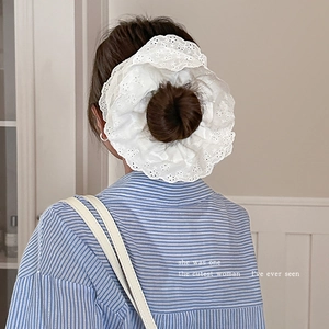Gedetailleerd beeld van een witte kanten scrunchie op een haarknot in vintage stijl