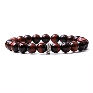 Macro shot of red tiger eye beads with a silver metal spacer on a white background