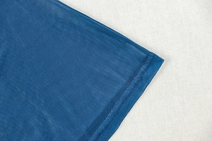 Detailed macro view of reinforced blue mesh fabric stitching on the garment hemline