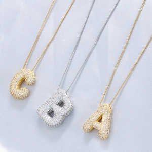 Macro shot of 18K gold and silver plated balloon letter A B C necklaces with CZ stones