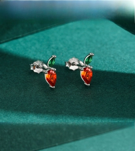 Macro view of S925 sterling silver carrot stud earrings with orange and green gems