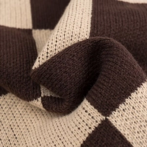 Detailed close-up of brown and beige checkerboard knit sweater fabric with soft texture