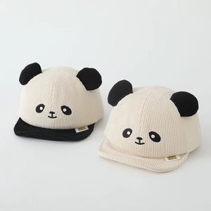 Close-up of corduroy baby caps with panda embroidery and 3D plush ears on white background