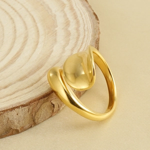 Polished 18k gold plated stainless steel open ring with fluid sculptural design on wood