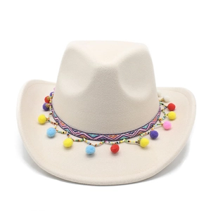 Détail d'un chapeau de cowboy en feutre beige avec pompons colorés et ruban bohème