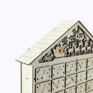 Macro detail of laser-cut wooden house advent calendar with numbered countdown drawers