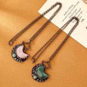 Close-up of vintage bronze moon and star pendants with rose quartz and green aventurine