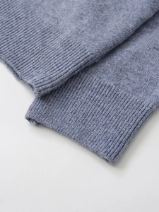 Close-up of ribbed cuffs on a dusty blue cashmere blend knit polo sweater