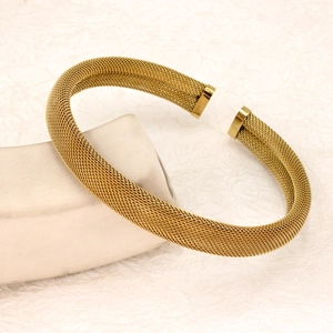 Detail shot of golden mesh open cuff bracelet with polished metal end caps