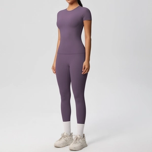 Close-up of purple high-waisted yoga leggings and slim-fit tee with elastic fabric texture