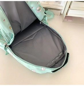 Internal view of mint green backpack showing spacious grey lining and durable zipper