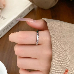 Detailed view of silver rings featuring colorful star-shaped zircon inlays on fingers