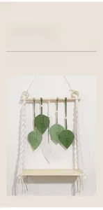 Détail d'étagère murale bohème tissée avec feuilles et plateau en bois naturel