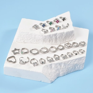 Close-up of assorted silver hoop earrings with butterfly, star, and heart zircon charms