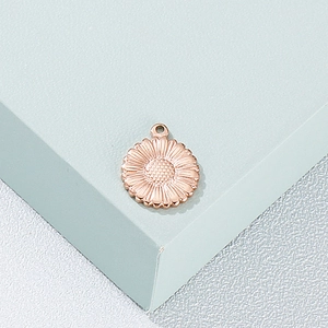 Pendentif tournesol en acier inoxydable or rose sur un support d'exposition moderne