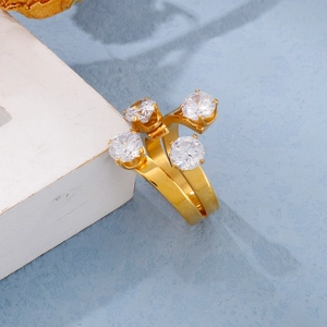 Detail of gold open ring featuring four sparkling crystals on a wide polished band