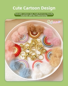 Detailed view of colorful rainbow pom-pom keychains with golden hooks and small bells