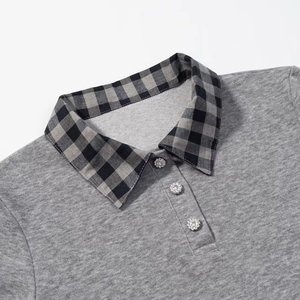 Detail view of grey knit polo top with plaid collar and floral decorative buttons