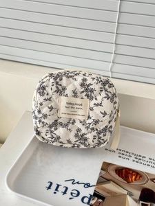 Quilted floral cotton cosmetic pouch with black and white print and zipper closure