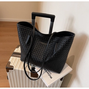 Detail showing the black woven texture and soft vegan leather of the large tote bag