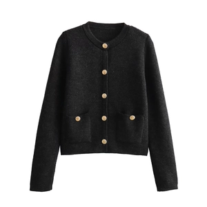 Detailed view of luxury gold embossed buttons on a classic black knit cardigan