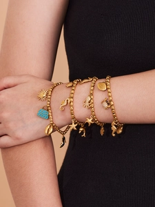 Primer plano de pulseras de amuletos marinos con estrella de mar y pulpo en la muñeca de modelo