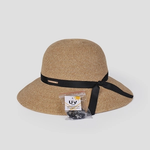 Detail of elegant straw sun hat with black ribbon, logo plate and UV care labels