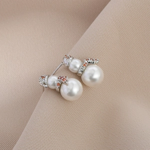 Detail of Christmas snowman earrings with white pearls and orange zircon accents